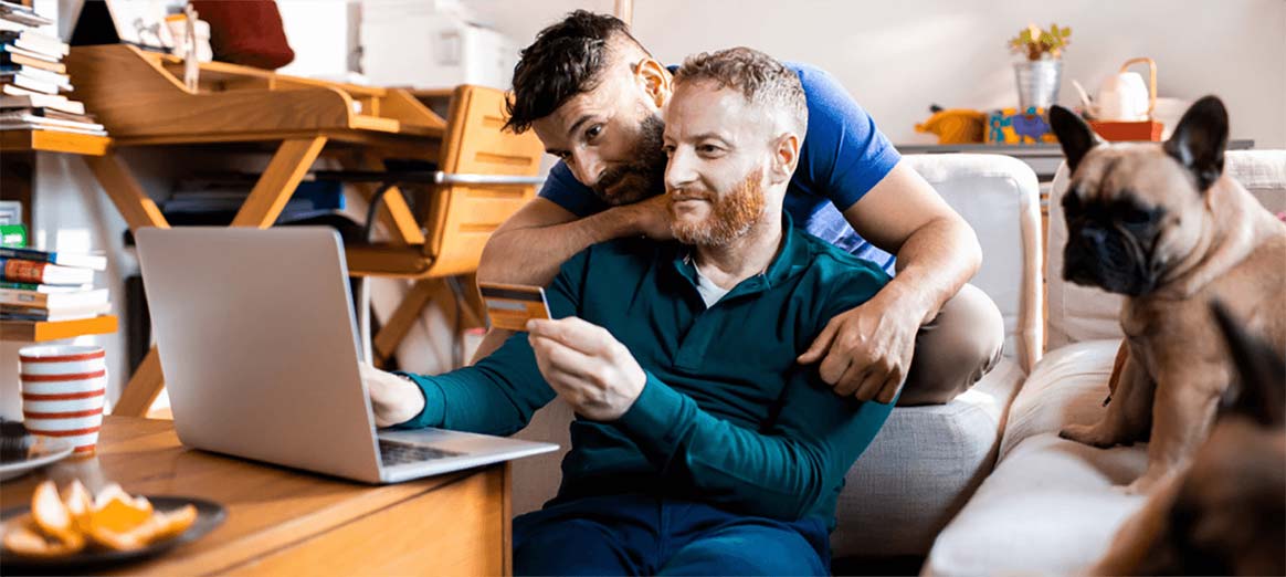 Image of two people looking at a laptop in a home office